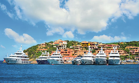 A church and a town are spotted amongst the trees and mountains on a Sardinia yacht charter